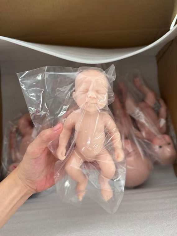 Unpainted silicone doll blanks in protective bags at the workshop
